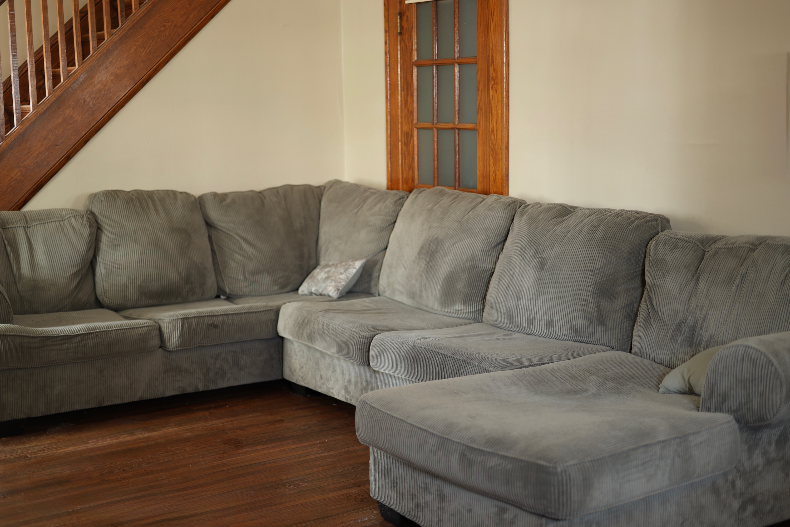 Tiffin living room with sectional sofa and wood staircase